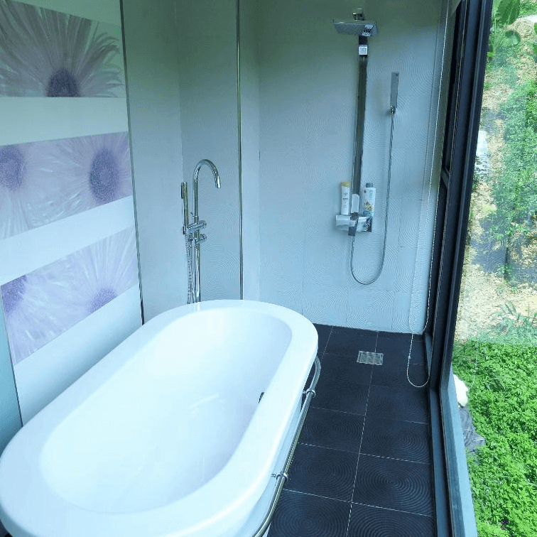 【埔里住宿】白舍·青丘玻璃窗為特色的浴室，內部設有白色獨立浴缸和淋浴設備。窗外可欣賞到自然景觀，空間採光良好，設計簡約且帶有自然感。