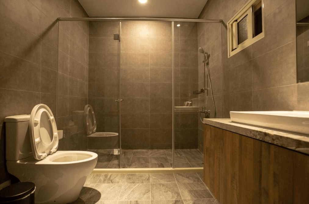 【阿里山住宿】茶緣觀舍的浴室以深色系瓷磚設計，搭配透明玻璃淋浴間與簡約洗手台，展現高雅的現代風格。空間寬敞且乾淨，提供舒適的使用體驗。