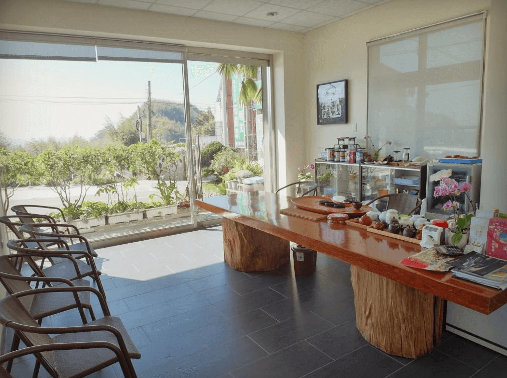 【阿里山住宿】茶雲居設有大木桌與多樣茶具的公共區域，提供旅客放鬆享用茶飲的空間。大片玻璃窗引入室外綠意，結合簡約裝飾，營造寧靜的交流環境。