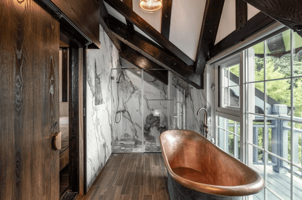 【埔里住宿】藍色城堡茱諾法式甜點設有銅製浴缸和大理石牆面，彰顯奢華氣派，同時採用大片玻璃窗設計，讓自然光線充足進入，提供舒適愜意的使用體驗。