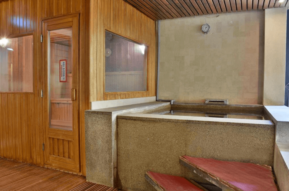 【廬山溫泉】蜜月館大飯店的室內泡湯區，以木質與石材結合設計，提供寧靜的泡湯空間。設有傳統烤箱與溫泉浴池，牆上時鐘顯示時間，讓住客在舒適的環境中放鬆身心，體驗純正溫泉文化。