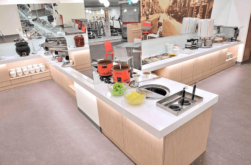 【寧夏夜市住宿】西悠巢旅-台北館飯店的自助餐區，設有整潔的長型自助台，提供多種料理選擇，牆面上有懷舊街景圖案，整體空間明亮且布置井然有序。