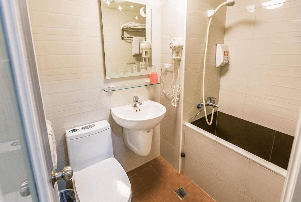 【寧夏夜市住宿】迪樂商旅的浴室設有淋浴和小型浴缸，牆面為白色瓷磚，配備洗手台、馬桶及基本洗浴設施，空間整潔且實用。