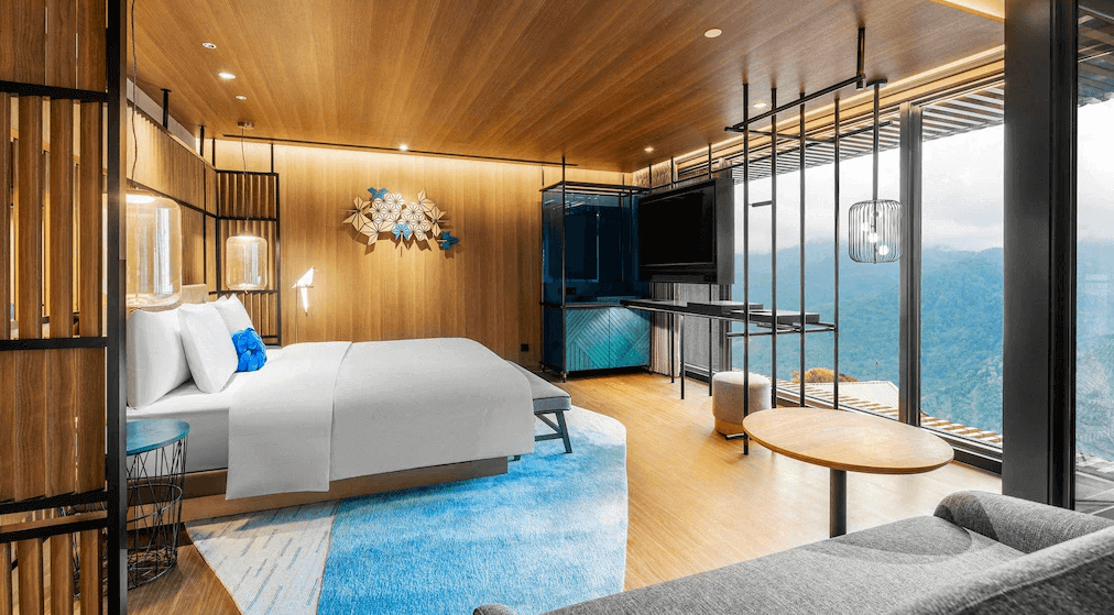 【阿里山住宿】阿里山英迪格酒店的
房間採用木質裝潢，搭配現代化的設計元素與柔和的燈光，營造出溫暖而高雅的氛圍。大面積落地窗提供壯麗的山景，讓住客能享受自然與舒適的完美結合。