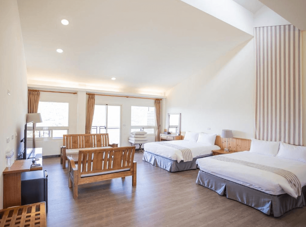 【司馬庫斯住宿】雲山房的家庭房，內部設有兩張雙人床與木製座椅，牆面掛有簡約裝飾，房間光線充足，透過窗戶可見戶外景色，適合全家人一起入住的溫馨空間。