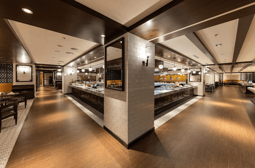 【松山機場住宿】「JR東日本大飯店台北」自助餐廳，裝潢融合日式與現代風格，木質設計搭配柔和燈光，營造高級用餐氛圍。餐檯提供多樣化的日式與國際料理，寬敞座位區適合多人聚餐或商務會議。