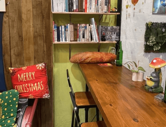 【鹿港住宿】公園一鹿背包客棧的一個小型休閒區，這裡有書架和溫馨的座位，讓住客能夠在這裡放鬆和閱讀。壁爐旁的座椅和書架提供了一個放鬆和休閒的理想場所，增添了空間的舒適感。