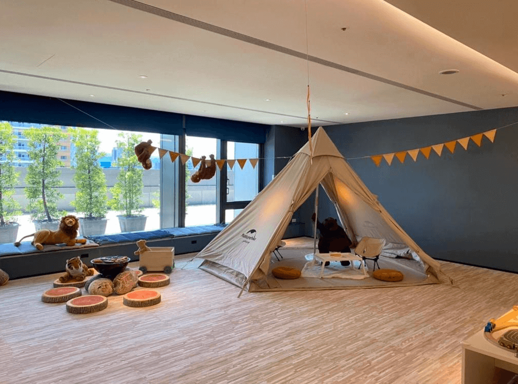 【台北親子飯店】台北凱達大飯店的親子遊戲區，以露營風格打造溫馨的兒童遊樂空間。場地內擺放帳篷、可愛動物玩偶與仿真露營裝飾，營造親子同樂的氛圍，讓孩子們能在安全舒適的環境中遊玩與探索。