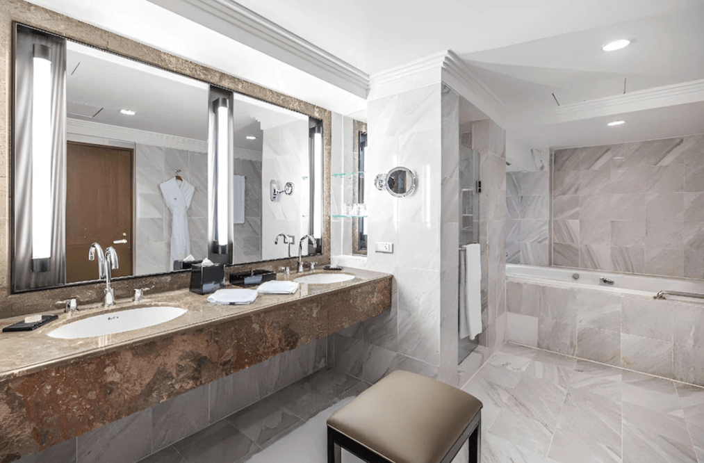 "台北親子飯店"【台北車站住宿】台北晶華酒店的大理石浴室，擁有雙洗手台、大型鏡面與現代感燈光設計。浴室內設有玻璃淋浴間、獨立按摩浴缸，並提供高級盥洗用品，展現奢華品味。