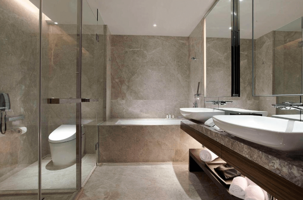 【台北親子飯店】台北艾麗酒店的高級浴室，以大理石紋理裝潢，呈現高雅風格。浴室內設有雙人洗手台、寬敞的玻璃淋浴間與獨立浴缸，並備有高級備品與毛巾收納架，提供極致的舒適體驗。