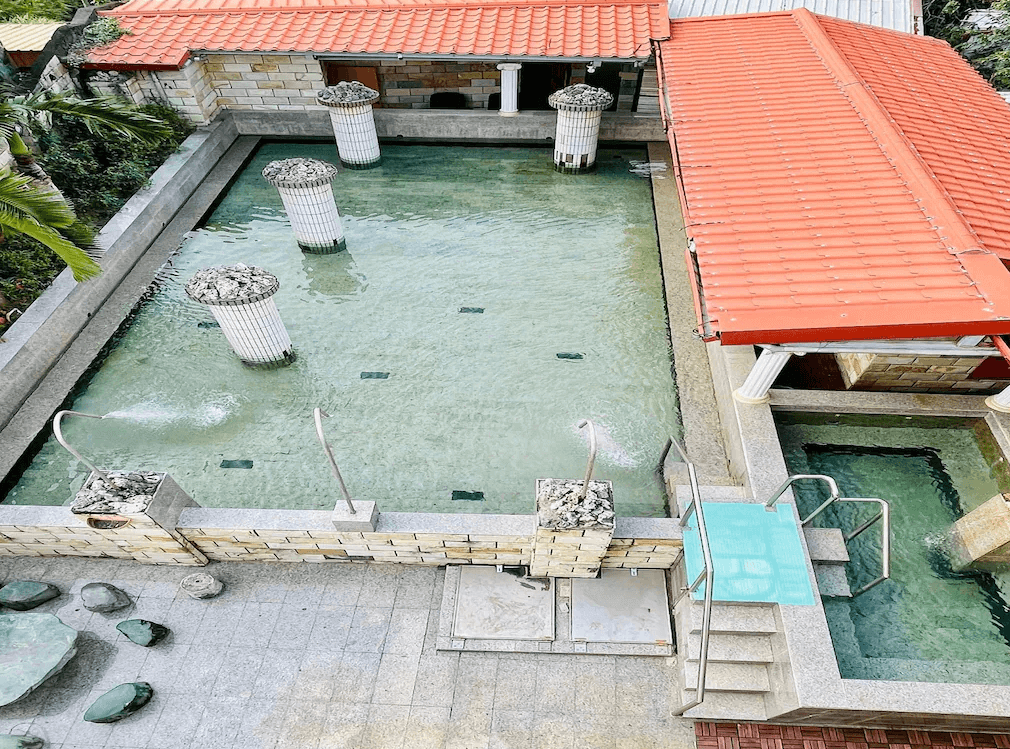 【四重溪溫泉】舍下立宇溫泉的露天溫泉池，泉水清澈，並設有多個噴泉水柱與階梯步道，方便進出。周圍環繞石牆與綠植，搭配紅瓦屋頂，營造傳統湯屋氛圍。設有冷熱水池，適合遊客在天然環境中放鬆身心，享受純正溫泉體驗。