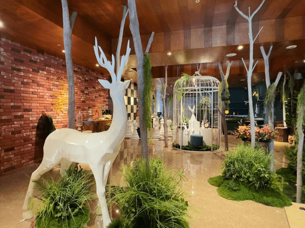【台北親子飯店】路境行旅的獨特公共空間，融合童話風格與自然元素。空間內擺設白色鹿雕塑、鳥籠造景與綠植裝飾，營造夢幻氛圍，讓旅客感受到如同森林童話般的體驗。