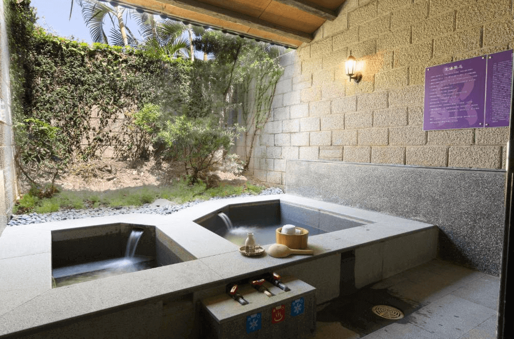 【金山溫泉】金湧泉溫泉汽車旅館的戶外私人溫泉池區，採用日式石材設計，並搭配兩個獨立泡湯池，可自由調整水溫。周圍綠意盎然，設有植栽與圍牆，確保隱私性，使住客能夠在大自然環境中享受寧靜的泡湯體驗。