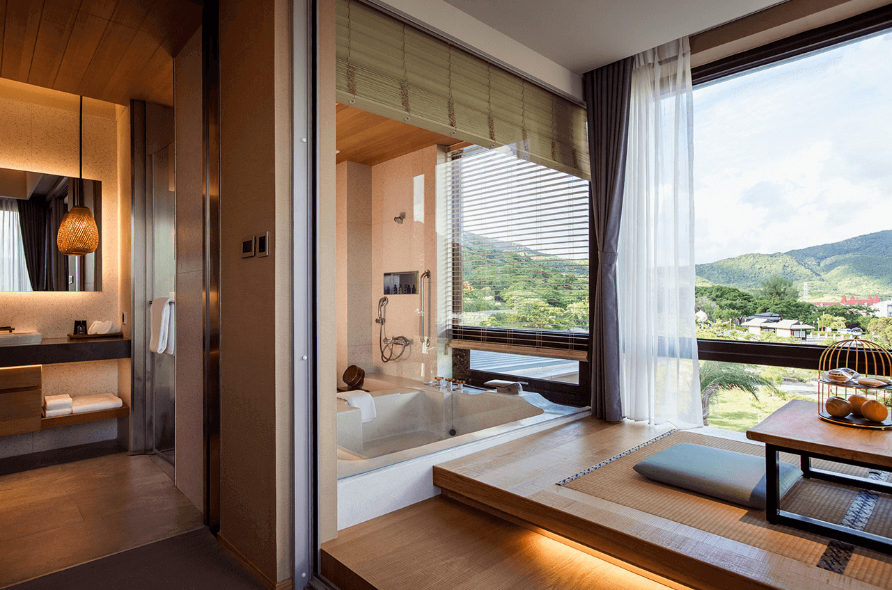 【四重溪溫泉】長鈺溫泉飯店的浴室與和式休憩空間相連，浴缸鄰近大面景觀窗，可享受山林景致。浴室採開放式設計，搭配現代燈光與木質裝潢，營造高級溫泉度假氛圍。