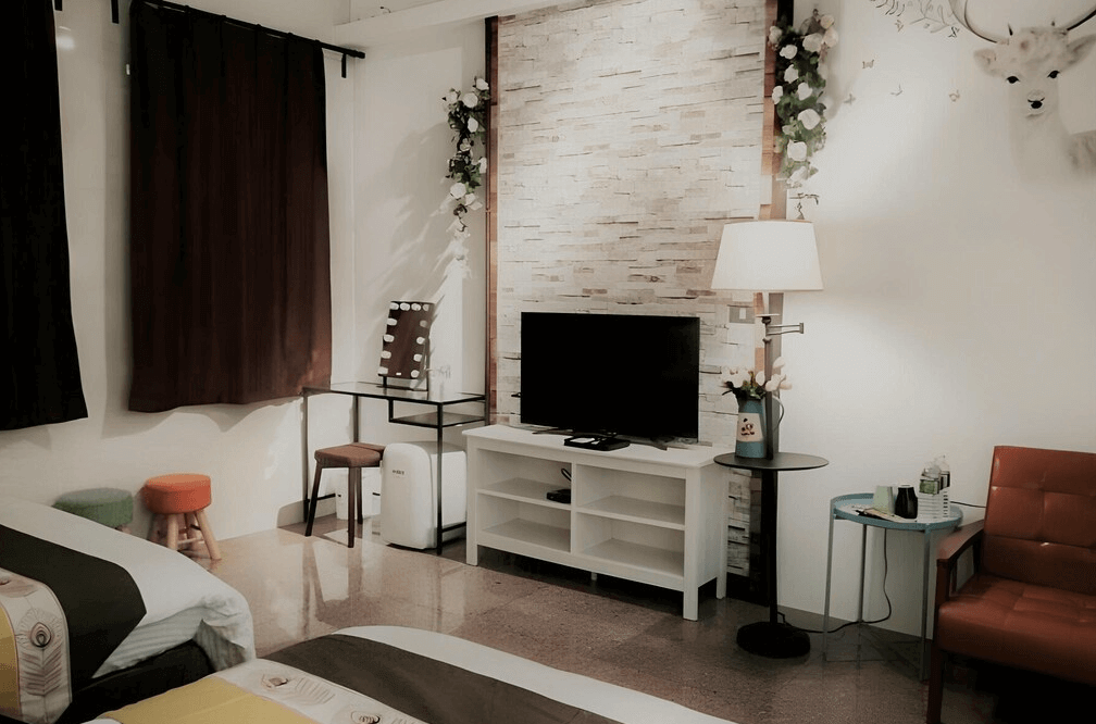 【鹿港住宿】鹿旅民宿的雙床房，房內以白色牆面和柔和的燈光搭配，營造出寧靜和放鬆的氛圍。牆面上有藝術畫作和白色的木質家具，增添了空間的舒適感與美感。