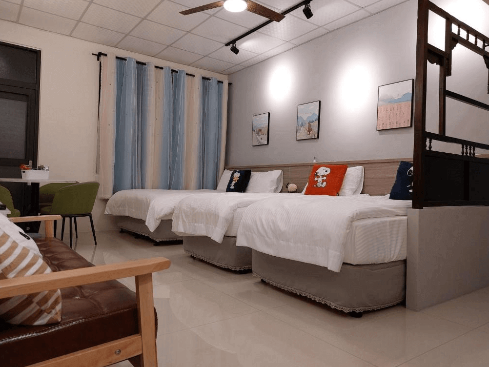 【鹿港住宿】鹿比民宿的雙床房，房內的裝潢保持簡約並具有現代感。特別的是，這間房間擁有明亮的窗戶和清新的顏色搭配，使整體空間顯得更加寬敞。床鋪設置簡單舒適，牆面上的插畫增添了一些趣味性。