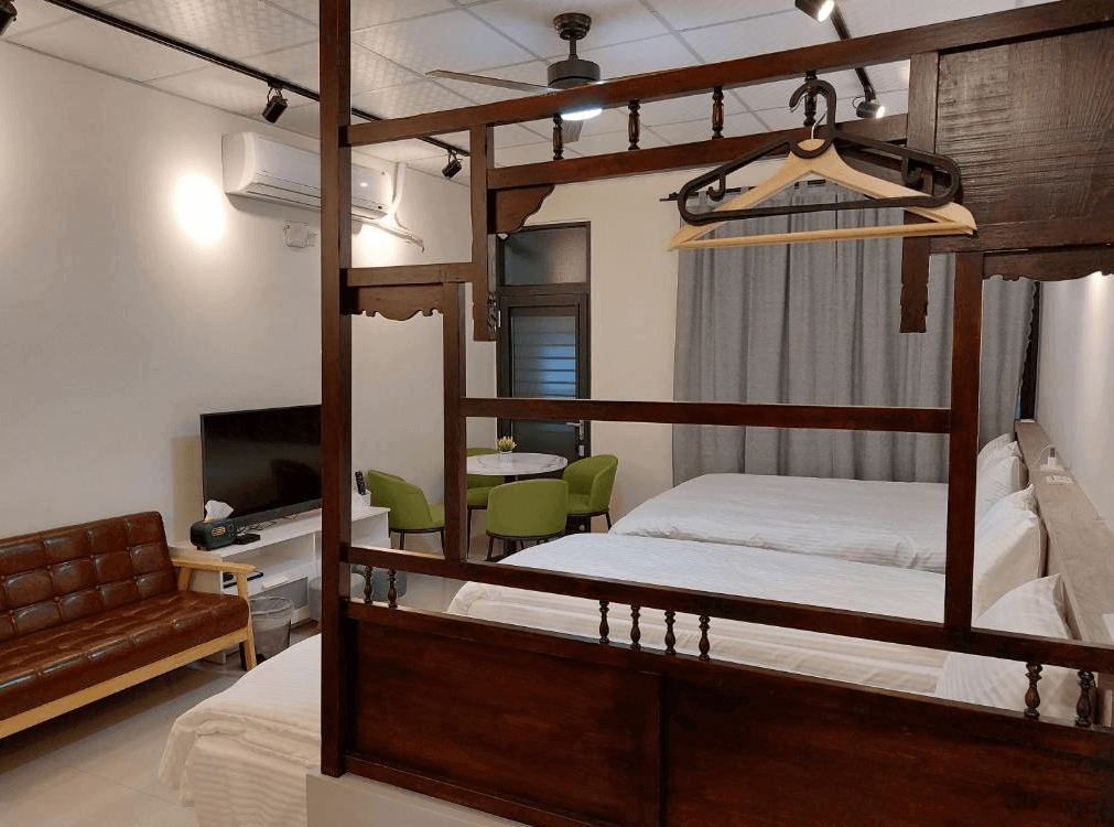 【鹿港住宿】鹿比民宿的座位區，這裡有沙發和桌椅，讓住客能夠輕鬆放鬆或享用餐點。該空間的裝飾保持簡單而富有設計感，木質元素與現代家居風格結合，打造出一個既舒適又實用的空間。