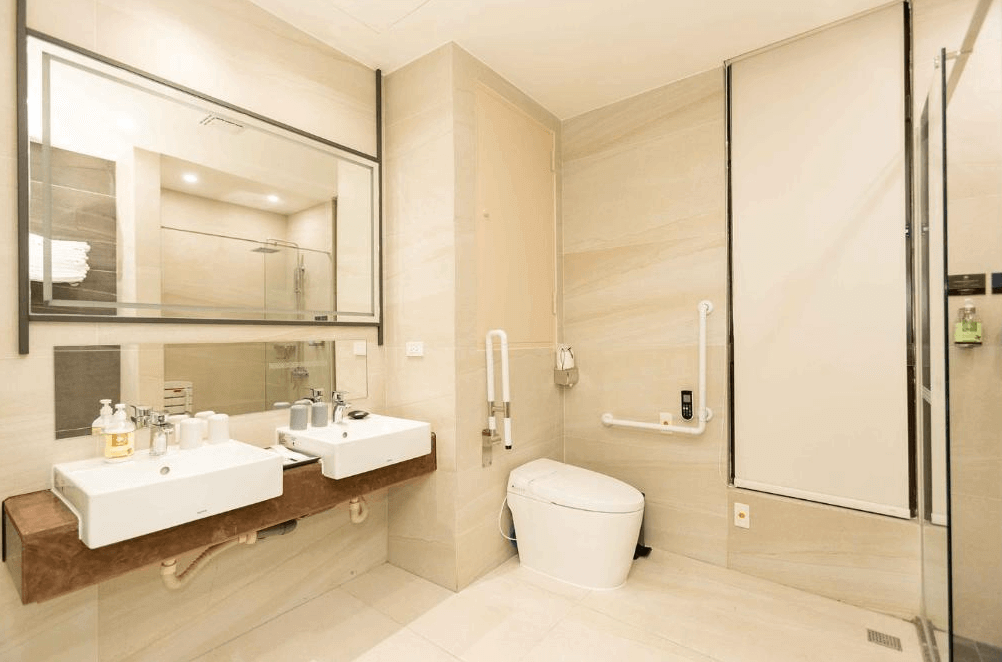 【鹿港住宿】鹿港澄悅酒店的浴室區域。浴室的設計時尚，配有大型鏡面和雙槽洗手盆，整體風格簡潔明亮。淋浴間與衛生間區域都設計得井井有條，提供了便利且舒適的使用體驗。