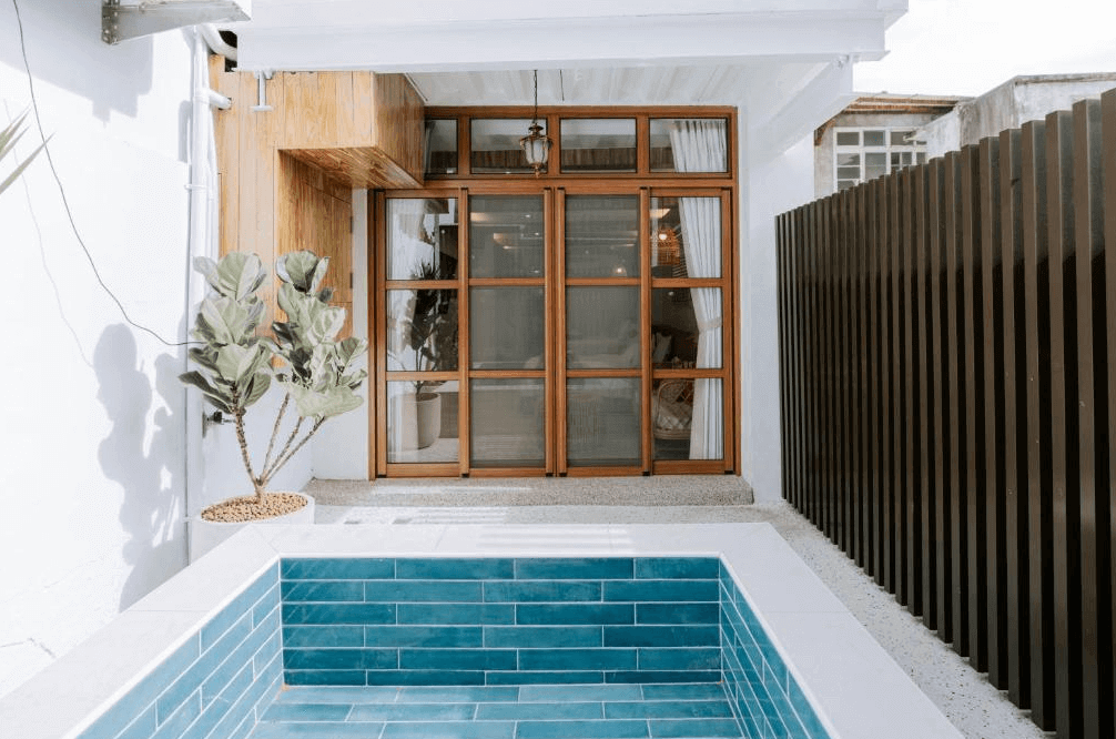 【鹿港住宿】鹿港老街十三號民宿的私密小型泳池，帶有深藍色瓷磚的設計與簡約的庭院佈置，這為住客提供了一個安靜放鬆的場所。周圍的木質圍欄與綠植搭配，增添了一份自然的氛圍，讓人感受到寧靜與舒適。