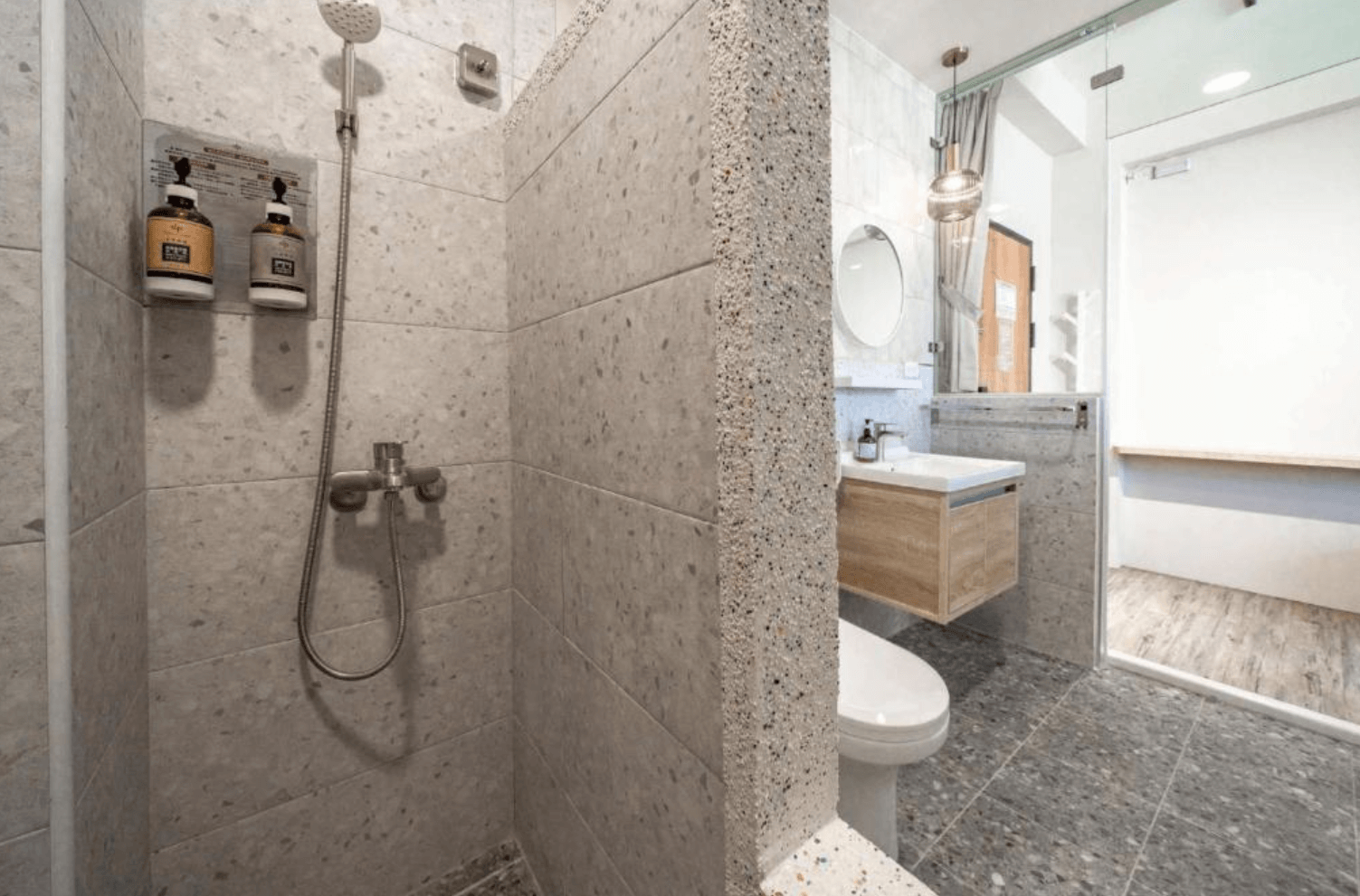 【台南安平住宿】安平宿沐的衛浴空間採用石紋磁磚設計，乾濕分離，設有獨立淋浴區與洗手台，提供香氛洗沐備品。整體環境乾淨整潔，設計注重實用與舒適。