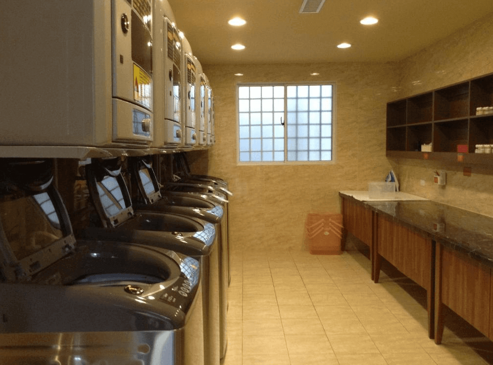 【高雄親子飯店】康橋商旅 高雄站前館飯店的自助洗衣房，設有多台洗衣機與烘衣機，供住客免費使用。空間整潔明亮，設有工作檯與收納架，適合長住旅客整理衣物，提供便利的自助洗衣服務。