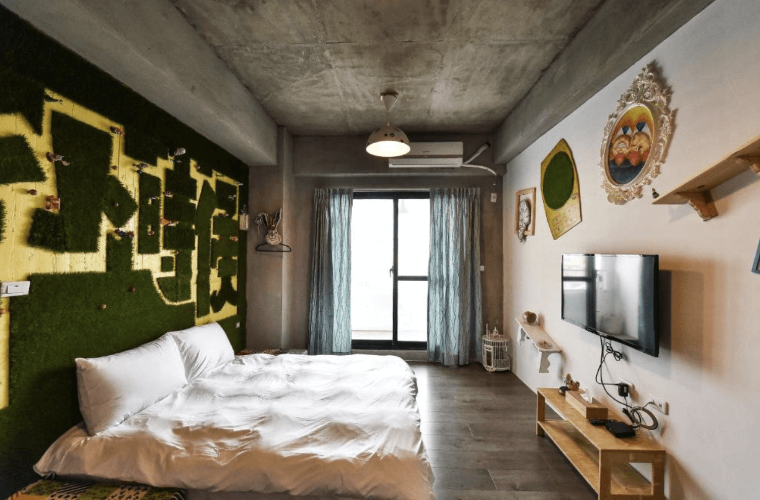 【台南安平住宿】我小時候設計旅店具有創意草皮塗鴉牆的客房，床鋪旁是以綠色與黃色交錯構成的立體文字設計，牆面上掛有童趣裝飾品，空間簡潔又富有童心。
