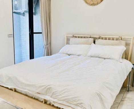 【虎尾住宿】日日見宅潔白床鋪的雙人房，牆面簡約、設計素雅，床邊為大面落地窗，空間明亮自然，營造出舒適清新的住宿氛圍。