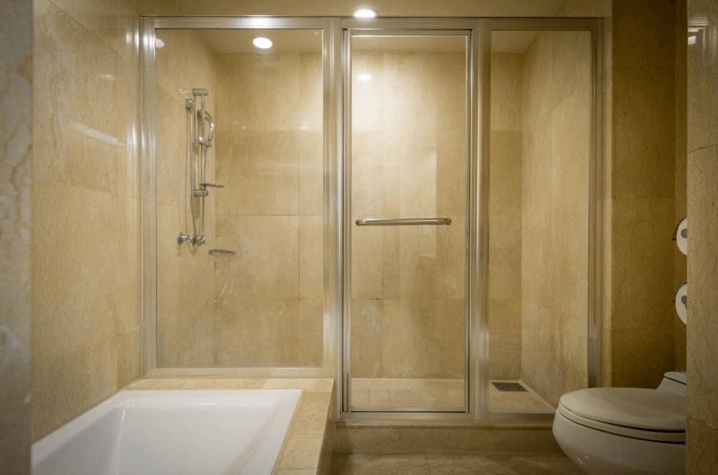 【員林住宿】"彰化飯店"昇財麗禧酒店的飯店浴室，採用大理石牆面與淺色瓷磚地板，設有獨立浴缸與玻璃淋浴間，乾濕分離設計提升舒適度。整體空間寬敞明亮，適合享受放鬆的沐浴體驗。