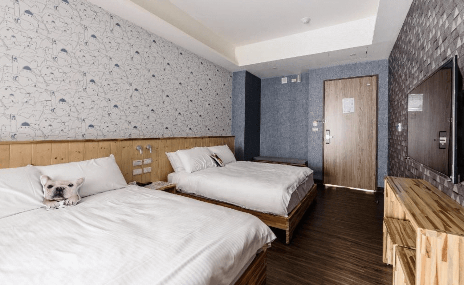 【台南安平住宿】樹屋文旅的雙床房，床鋪以原木平台架高設計，牆面使用可愛插畫與藍灰色系搭配，整體感受清新又不失趣味，適合親子或朋友同住。