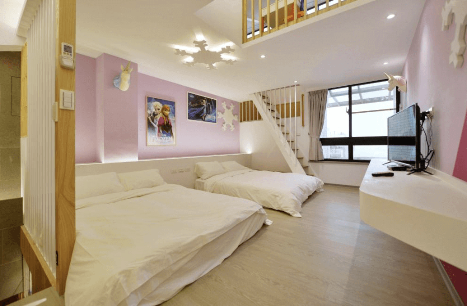 【台南安平住宿】溜小孩親子民宿以《冰雪奇緣》為主題的親子房，牆面彩繪艾莎與安娜的劇照，配有兩張大床與挑高樓中樓設計，柔和的粉紫色牆面搭配雪花吊燈與獨角獸造型燈飾，營造出夢幻童話氛圍，深受小女孩喜愛。