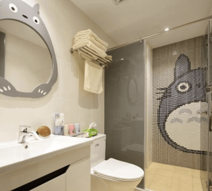 【台南安平住宿】溜小孩親子民宿可愛童趣的浴室設計，以《龍貓》為主題，淋浴間牆面以馬賽克拼貼出龍貓圖案，搭配同系列鏡框與馬克杯等小物，細節滿分。整體衛浴空間乾淨整潔，風格一致，深得親子旅客喜愛。