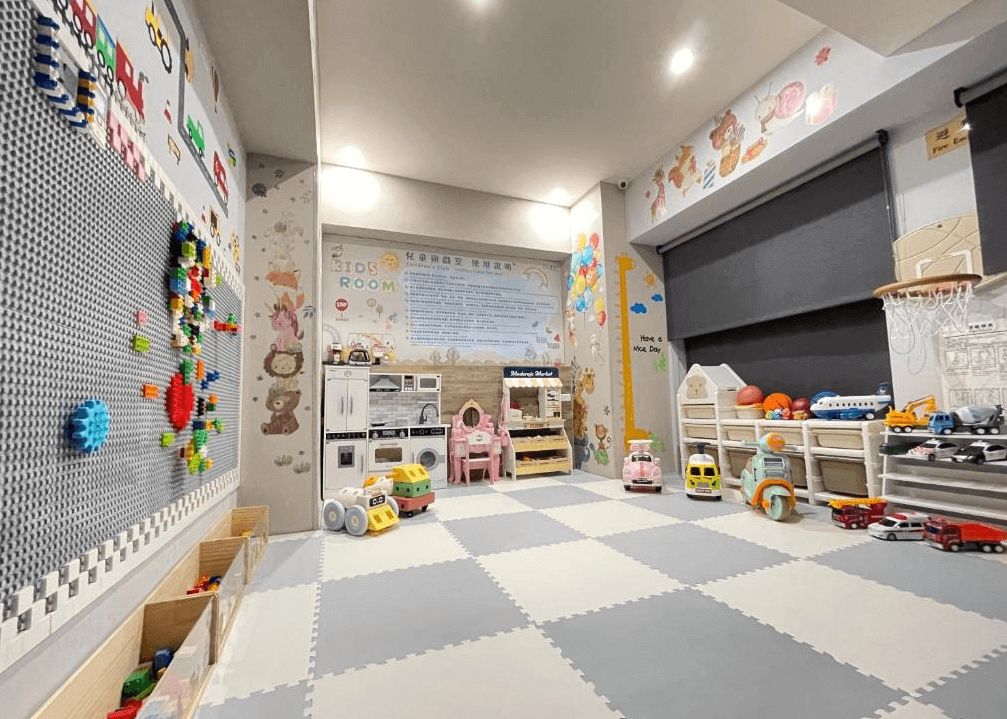 【虎尾住宿】虎尾春秋文創設計旅店的兒童遊戲室充滿童趣與色彩，牆面貼有可愛動物與汽車圖案，地面鋪設安全軟墊，配備多款玩具車、積木牆與小型廚具組，是親子旅客放鬆同樂的理想空間。