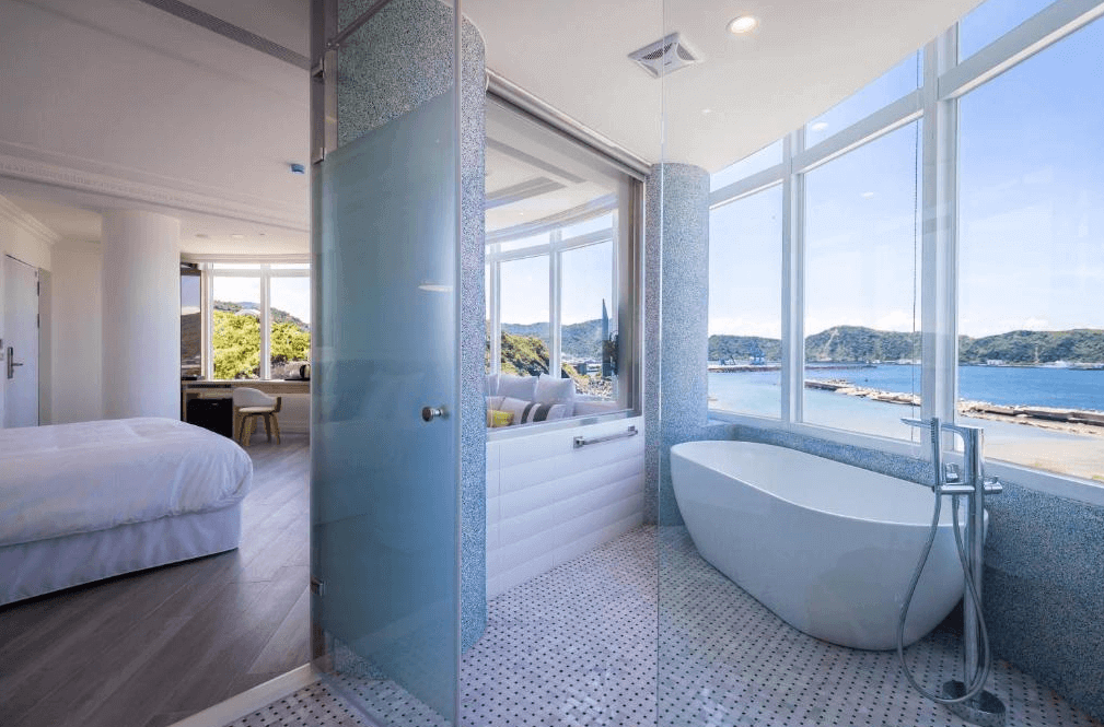 【蘇澳住宿】BRIGHTHOUSE 光之旅的房內衛浴空間設於窗邊，設有獨立浴缸與淋浴間，可一邊泡澡一邊欣賞海景，浴室與臥室間以玻璃隔間設計，視野開闊、光線充足。