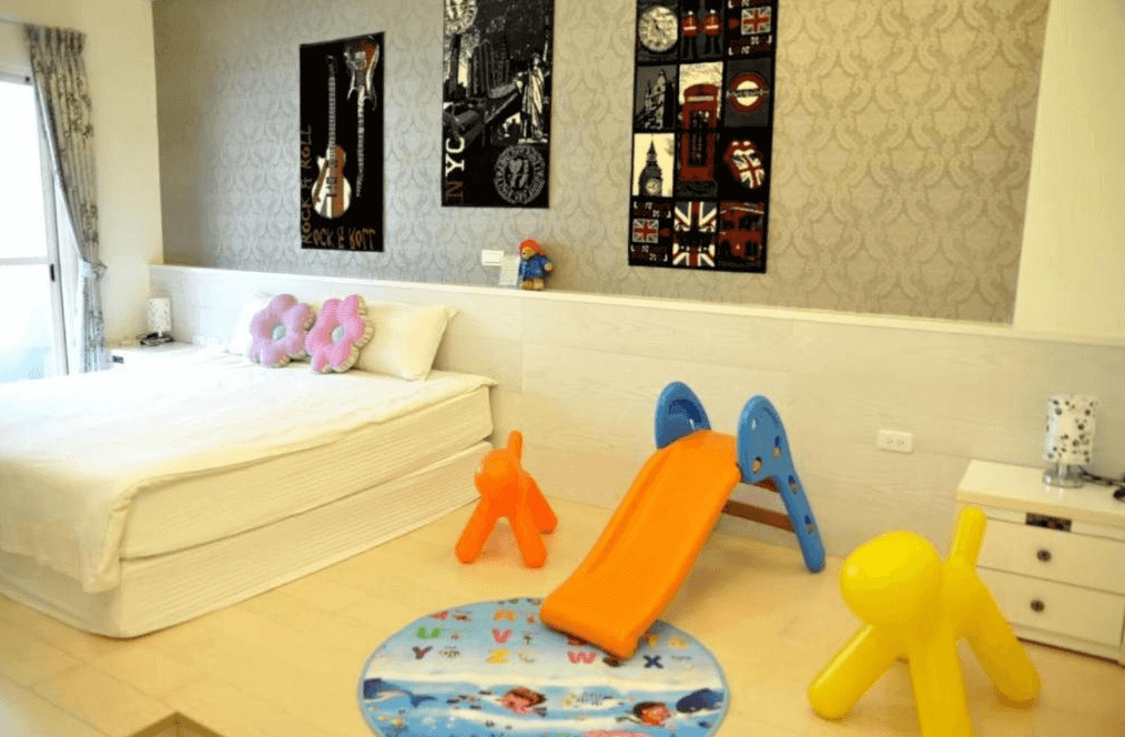 【五結住宿】D3經典民宿適合孩童的親子主題房，設有溜滑梯、動物造型椅與字母遊戲地墊，房內擺放雙人床與花朵抱枕，牆面掛有搖滾與英倫風裝飾畫，充滿活潑氣息。