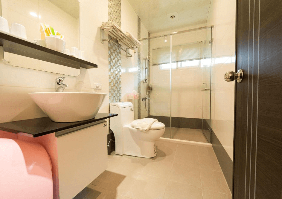 【五結住宿】D3經典民宿的現代風格衛浴空間，配備乾濕分離淋浴間、圓形面盆與免治馬桶，牆面設有置物層架與毛巾架，整體簡約明亮且乾淨整潔。