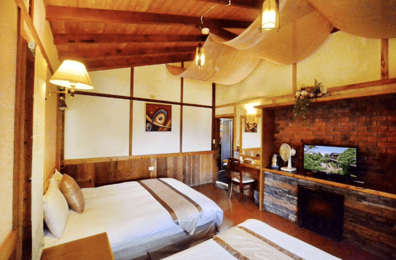 【清境農場住宿】事外桃源渡假山莊的木屋鄉村風格雙床房，設有兩張大床與挑高天花板，天花布幔裝飾增添浪漫氣息，牆面以紅磚與木質混搭，房內設備齊全，適合家庭或朋友入住。