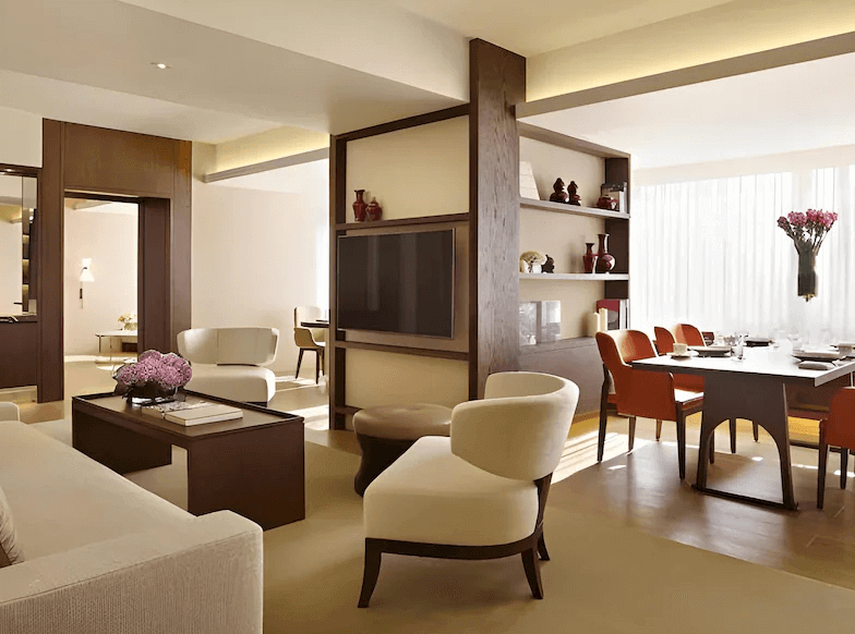 【台灣最貴飯店】台北君悅酒店的總統套房內部空間寬敞，設有獨立起居室與可容納多人用餐的餐廳區，裝潢溫潤典雅，融合木質元素與中式擺飾，適合高階商務與家庭聚會。