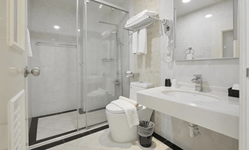 【東港住宿】大鵬灣瞭望台民宿的浴室採用白色磁磚與玻璃拉門設計，配置圓形洗手台、馬桶與淋浴空間，整體乾淨整潔，機能性佳。