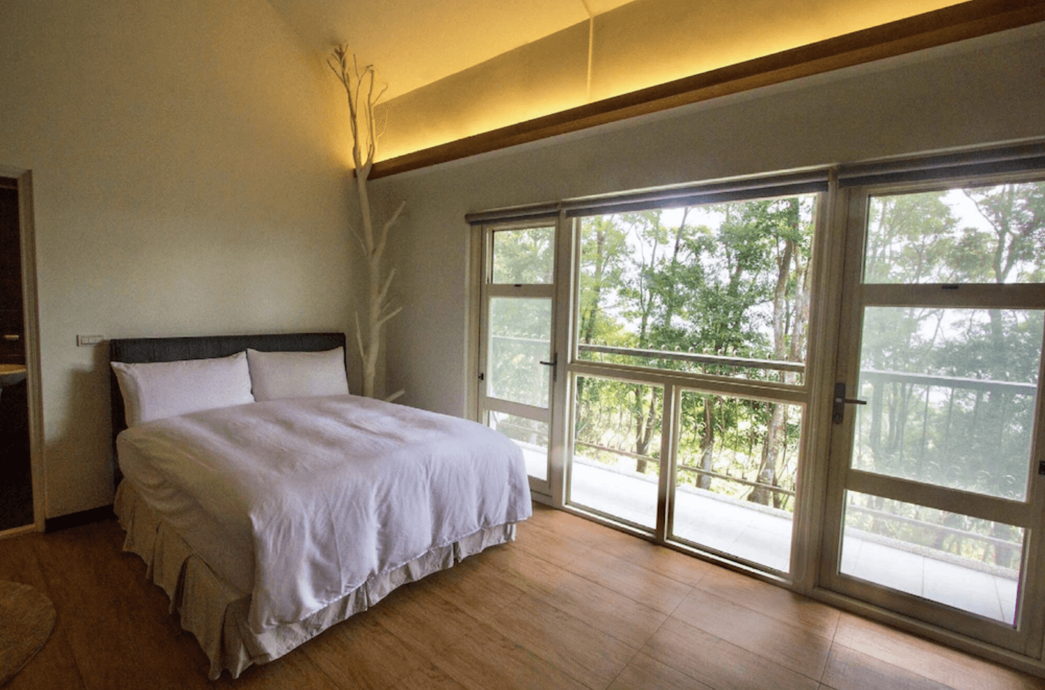 【三義住宿】尋路苗栗綠波浪的簡約森林系雙人房，搭配落地窗與木質地板，柔和燈光營造靜謐氛圍，窗外綠意環繞，享受與自然共眠的寧靜時光。