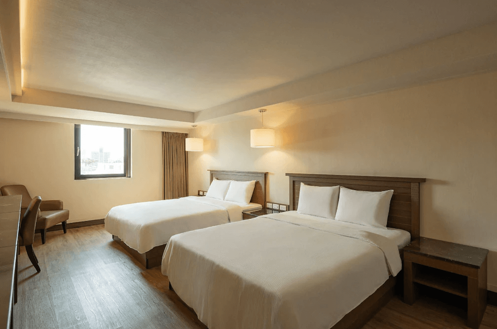 【彰化飯店】康橋商旅彰化員林館家庭四人房，配置兩張大床與沙發椅，整體設計風格溫潤沉穩，採光良好。