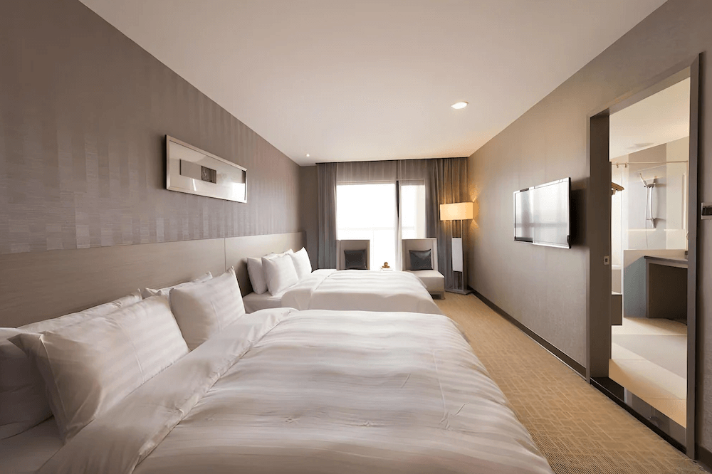 【彰化飯店】彰化福泰商務飯店家庭四人房，設有兩張大床與窗邊休憩區，整體空間寬敞，適合親子或多人入住。