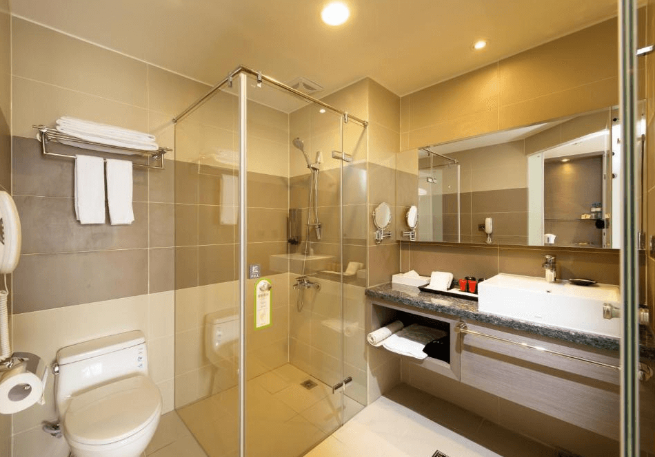 【彰化飯店】彰化福泰商務飯店衛浴空間，配有乾濕分離淋浴間、洗手台與馬桶，設施齊全且採光良好。