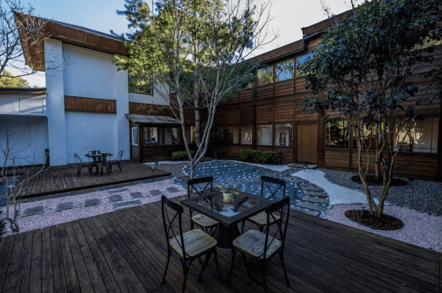 【清境農場住宿】愛薰閣會館的庭院景觀，設有木質平台與戶外桌椅，圍繞著日式風格庭園，營造靜謐的住宿氛圍。