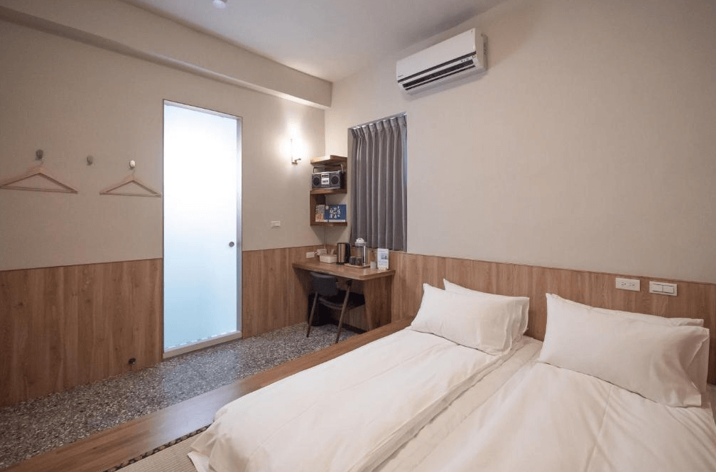 【彰化飯店】東皋歇暝雙床房，簡約木質風設計，附有書桌與熱水壺，採光良好並提供掛衣架與冷氣設施。