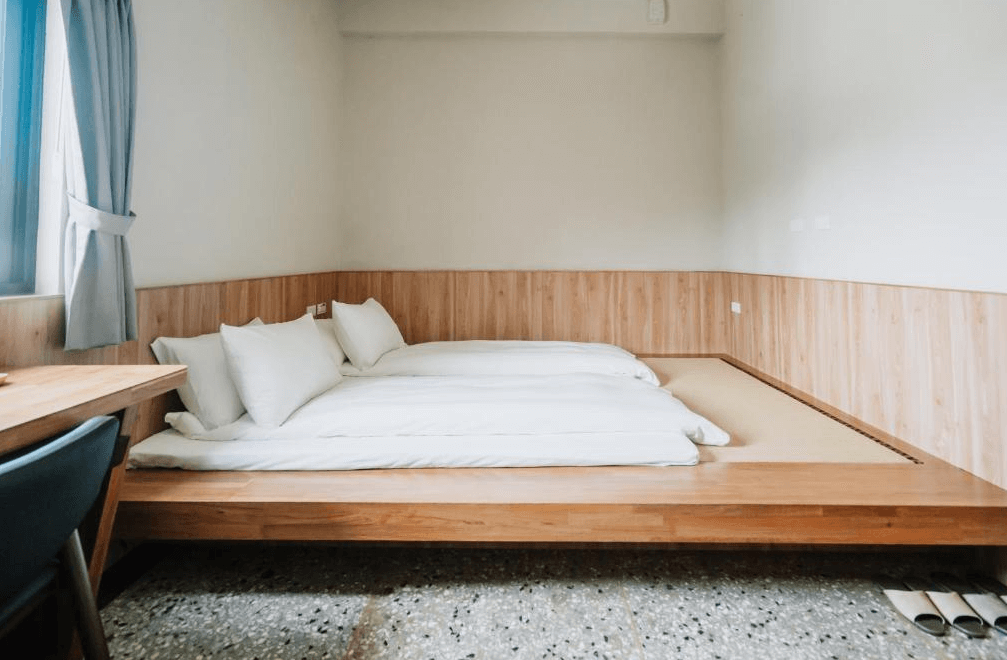 【彰化飯店】東皋歇暝日式通鋪房型，設有三人寢位與木質地台，搭配磨石子地板與書桌，空間寬敞適合家庭入住。