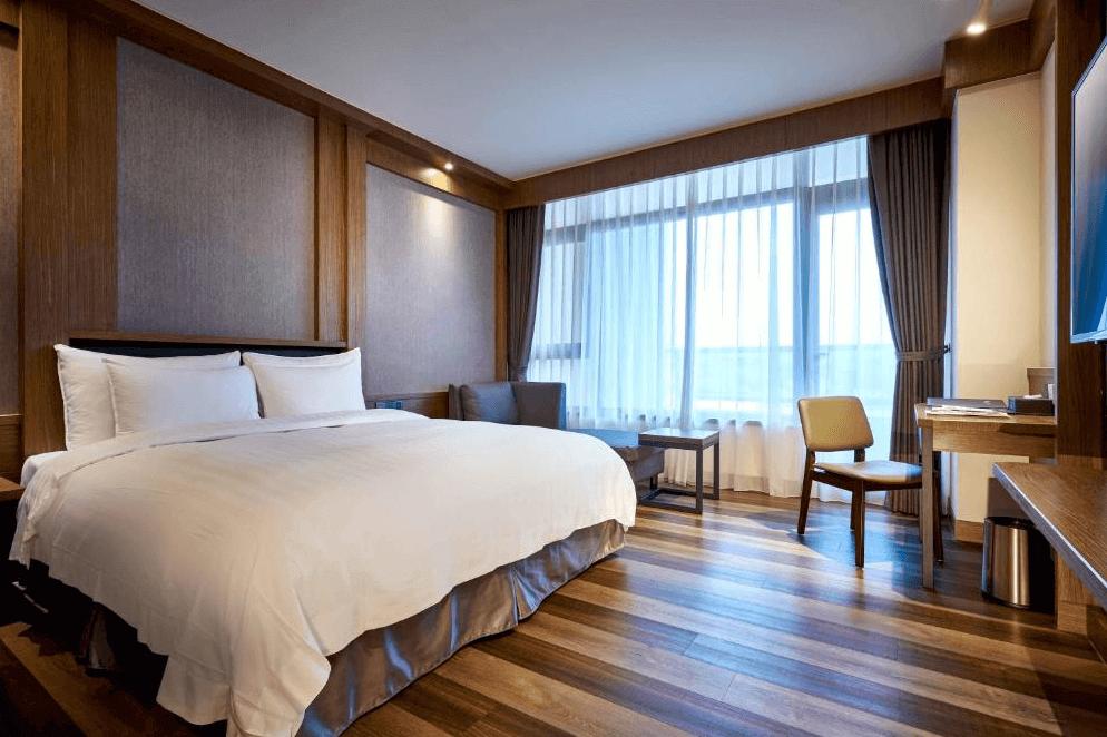 【五結住宿】松風文旅典雅簡約的雙人房，設有大面積窗景、木質地板與工作桌椅，整體色調溫潤，採光良好，營造沉靜舒適的住宿環境。