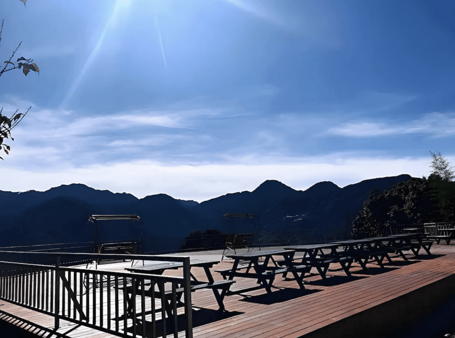 【清境農場住宿】清境之星樂活民宿的戶外觀景平台配有多組木製長桌椅與鞦韆椅，可俯瞰清境壯麗山景與湛藍天空，是欣賞日出日落與星空的絕佳場所。