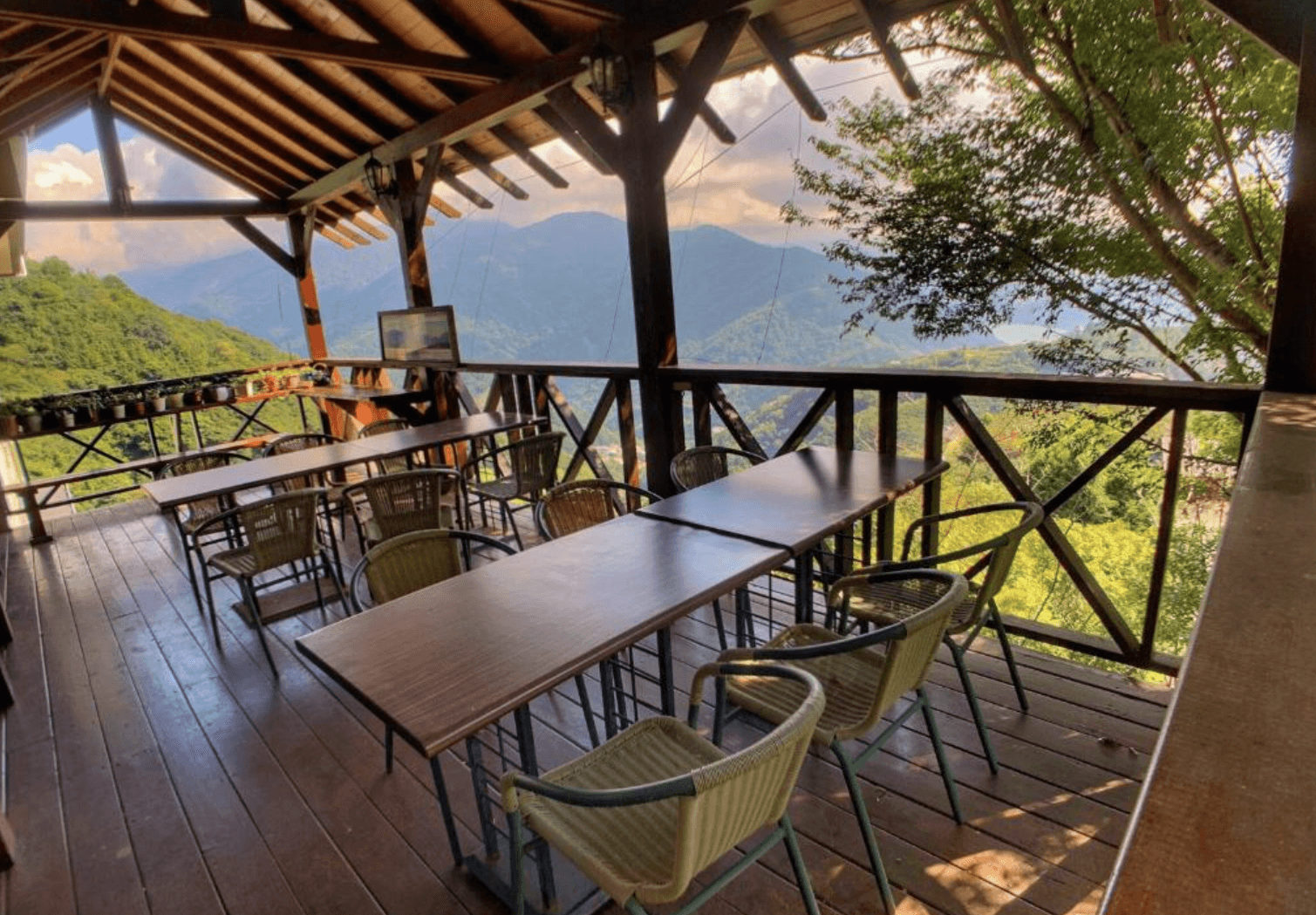 【清境農場住宿】清境天祥景觀民宿屋頂遮蔭的戶外觀景用餐區，擺放多組桌椅可容納團體聚餐，四周被青山綠意圍繞，視野開闊、空氣清新，是享受早餐或午後茶點的理想場所。