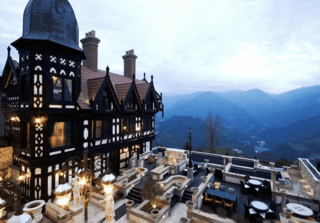 【清境農場住宿】"清境農場住宿精選示意圖""台灣最貴飯店"清境老英格蘭莊園外觀，呈現黑白木筋牆的英國都鐸式建築風格，周圍環繞著多層次石砌露台與戶外座位區，遠眺合歡山山景壯麗迷人，彷彿置身歐洲山中古堡。