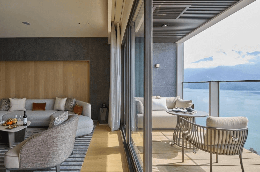 【台灣最貴飯店】漢來日月行館寬敞明亮的客廳連接湖景陽台，室內配有現代感沙發與休閒座椅，陽台設有戶外沙發與茶几，可遠眺日月潭景色，展現極致度假享受。